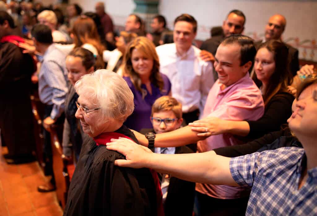 giving day celebration where a family has kep their hands on a grandmothers' shoulder