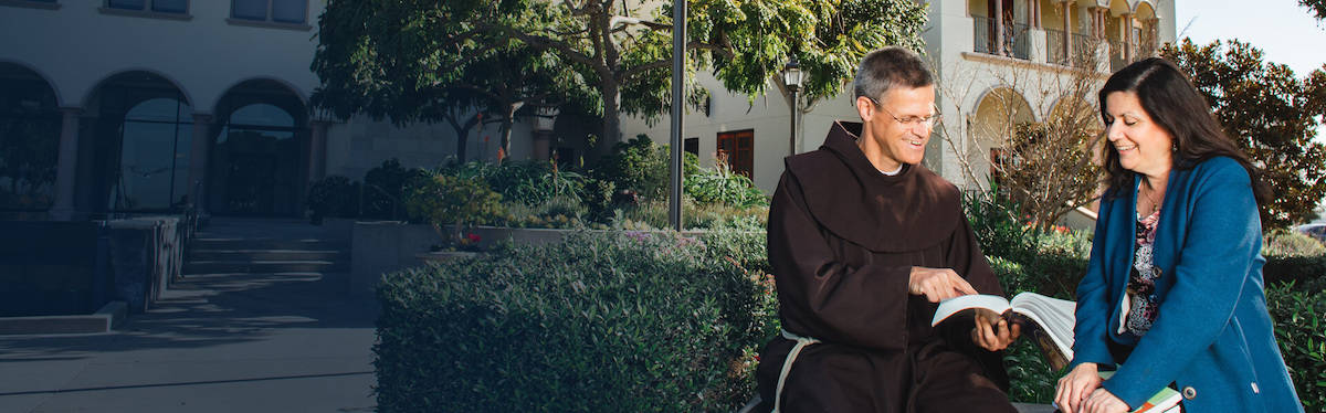 pastor-sitting-with-woman-in-front-of-faded-background-of-greenery.