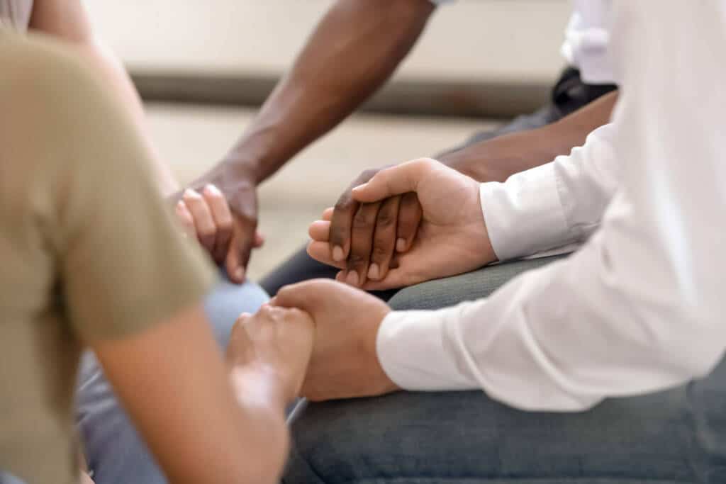 group of people holding hands in a circle. this image is a close-up of people's hands. group of people holding hands in a circle. this image is a close-up of people's hands.