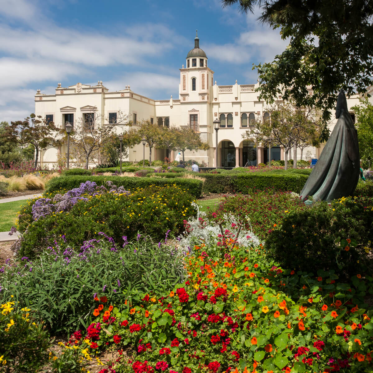 outside shot of large white building with flower garden in front of it