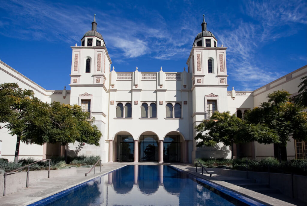 image of large white building with large blue pool in front of it