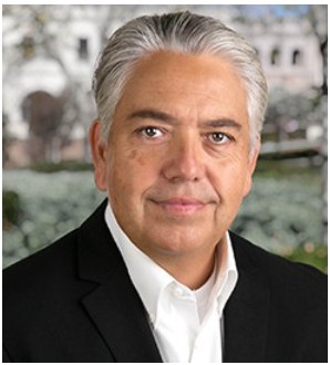 Middle-aged man with gray hair wearing a black blazer and white shirt.