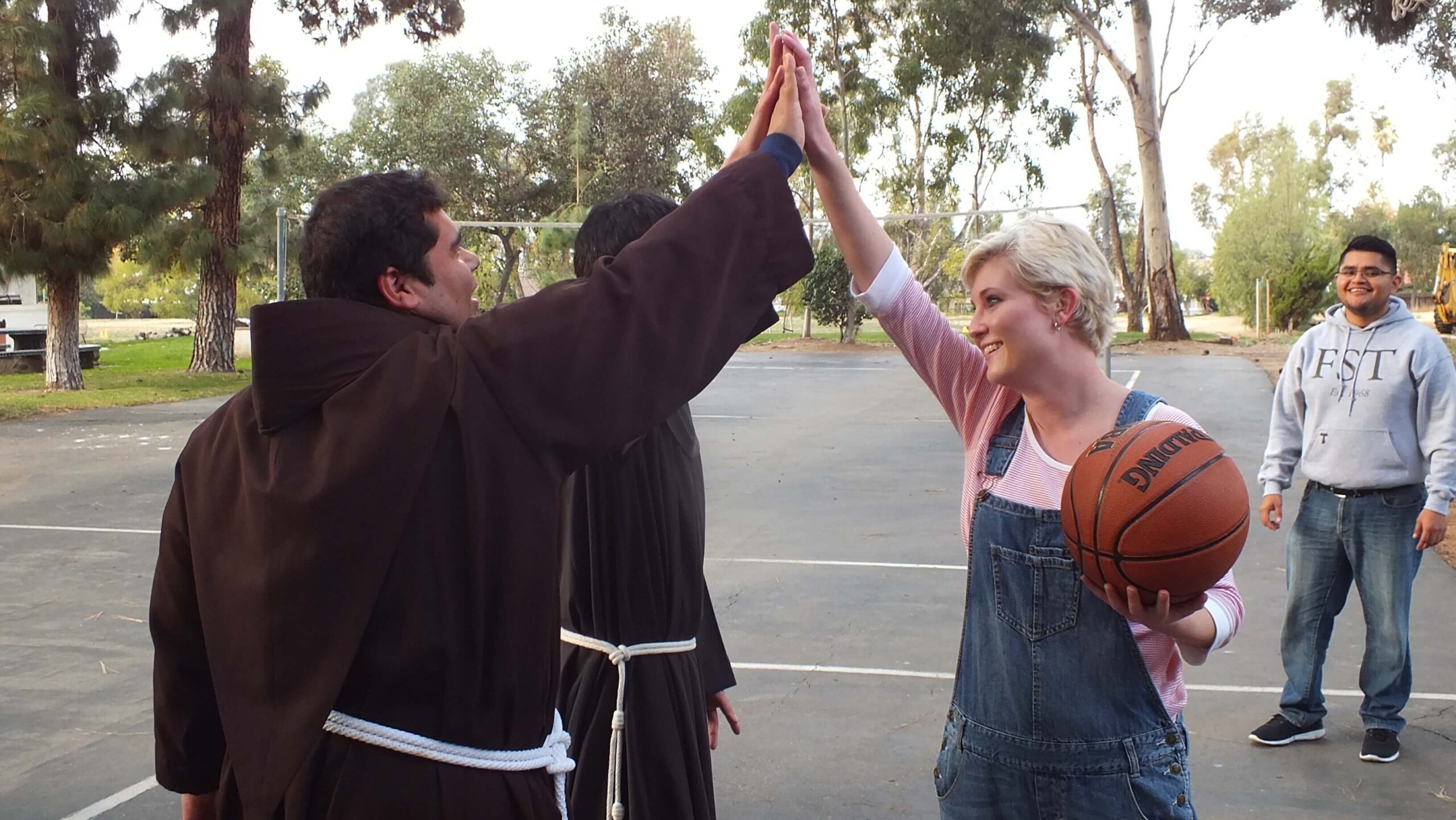sports chaplain high-fiving a player during a basketball game